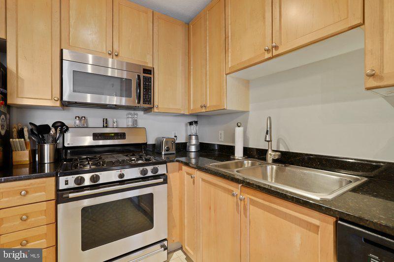 851 North Glebe Road, Unit 520 Arlington, VA 22203 - Photo 6 of 28 a kitchen with granite countertop a sink a stove and cabinets