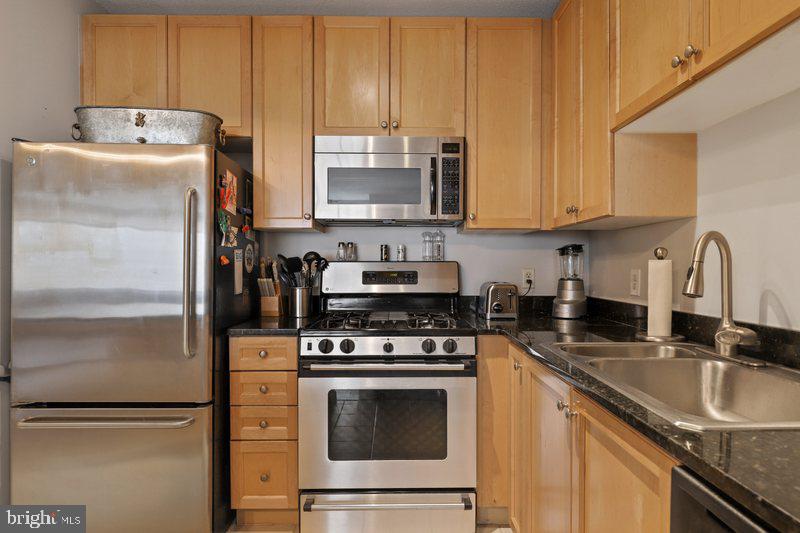 851 North Glebe Road, Unit 520 Arlington, VA 22203 - Photo 9 of 28 a kitchen with granite countertop a refrigerator stove and sink