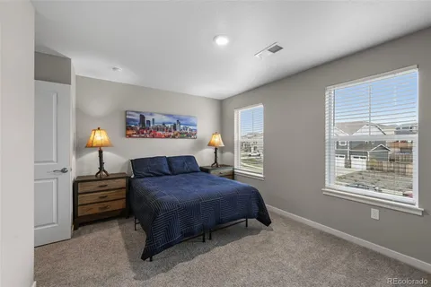 a bedroom with a bed and dresser next to a window