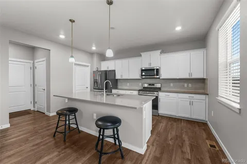 a kitchen with stainless steel appliances granite countertop a stove a sink a refrigerator and a microwave