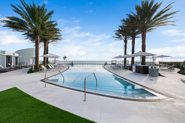 a swimming pool with a bench and trees