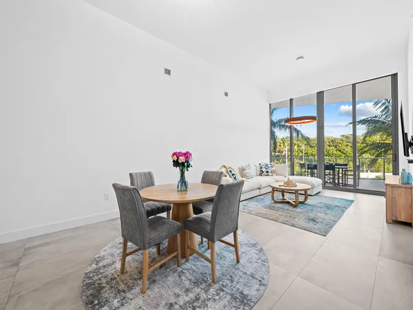 a view of a dining room with furniture large windows and wooden floor