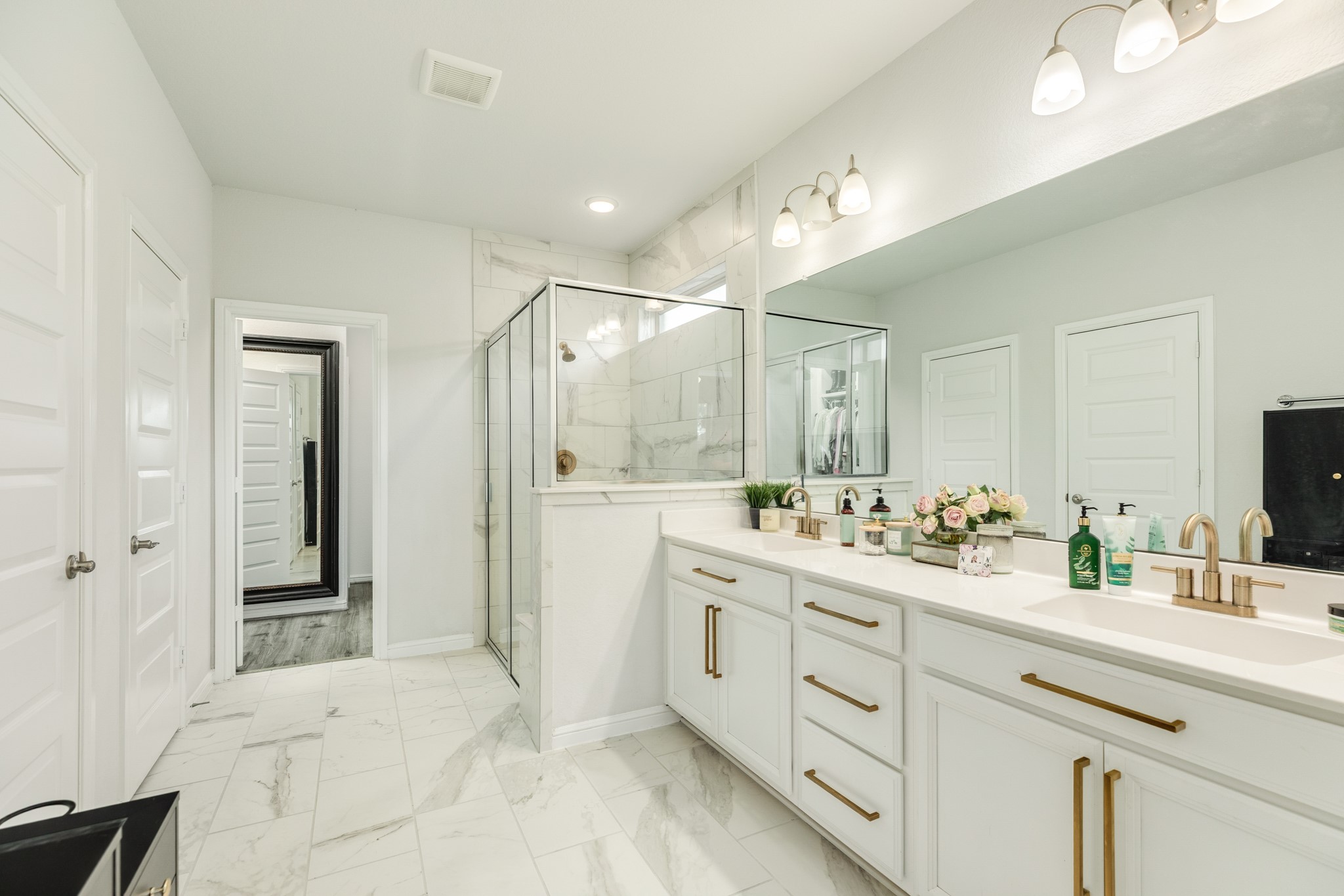 10306 Aldrin Drive Rosharon, TX 77583 - Photo 18 of 50 Primary bath boasts double vanities, elegant gold trim hardware, and a luxurious double walk-in glass shower.