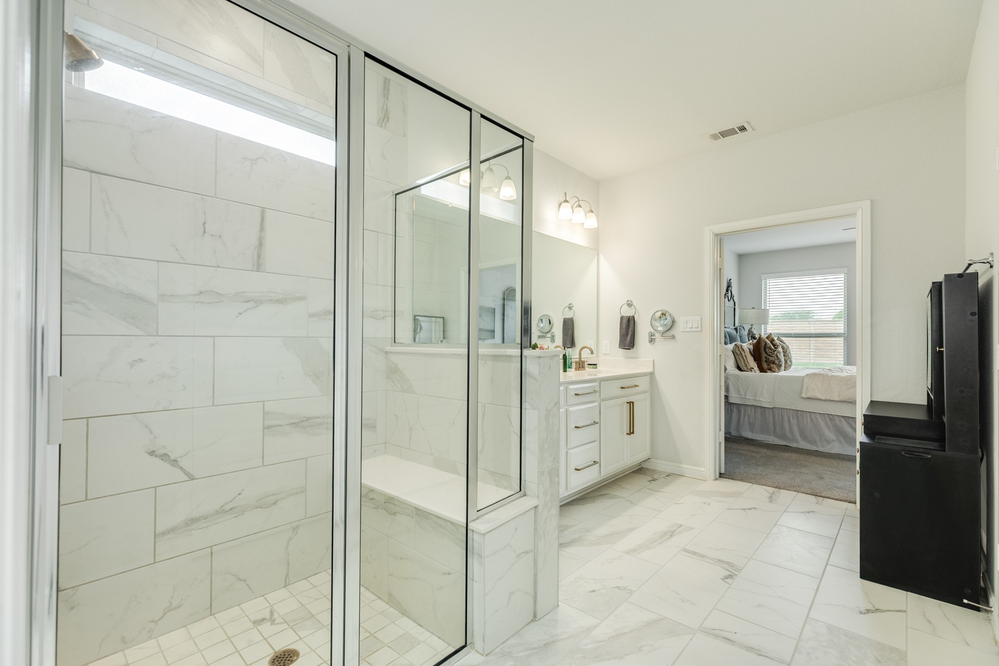 10306 Aldrin Drive Rosharon, TX 77583 - Photo 19 of 50 The double glass walk-in shower features a seat for convenience, tile flooring, and ample space.