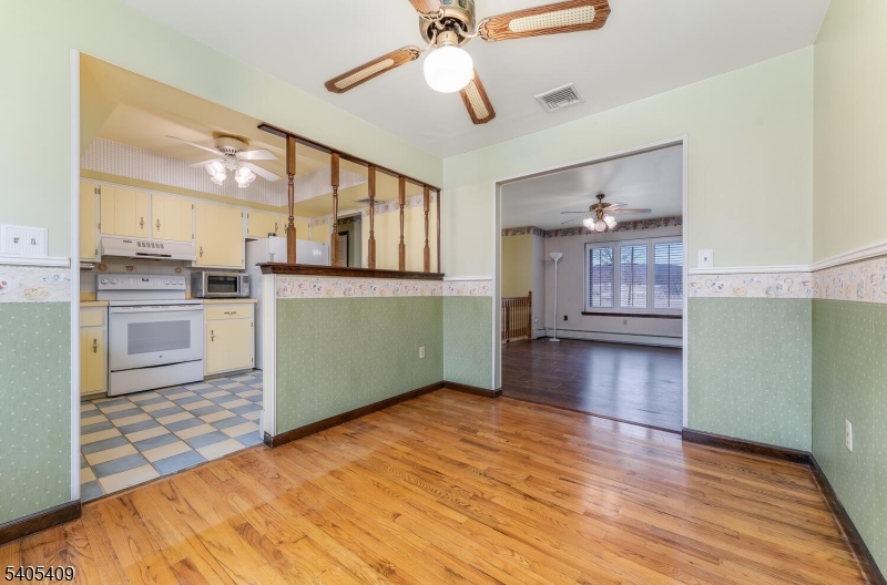 217 Van Syckles Road Hampton, NJ 08827 - Photo 7 of 16 a view of a kitchen with wooden floor a ceiling fan and staircase