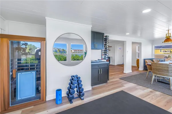 a living room with couches and a dining table with wooden floor