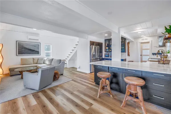 a kitchen with stainless steel appliances a dining table chairs and wooden floor