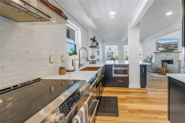 a kitchen with stainless steel appliances granite countertop a refrigerator and a sink with wooden cabinets