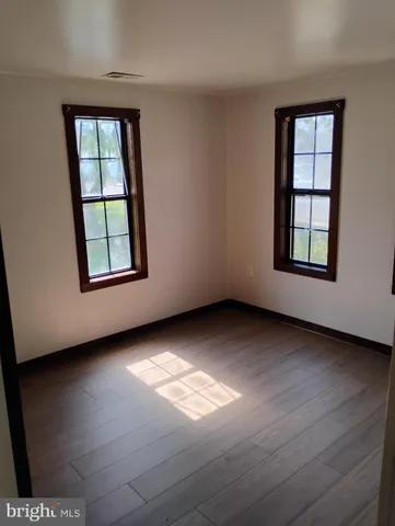 an empty room with wooden floor and closet