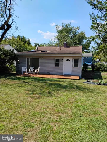 a front view of house with yard and trees in the background
