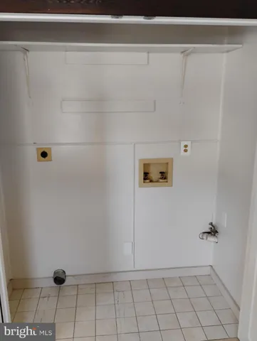 a view of an empty room with wooden floor and closet