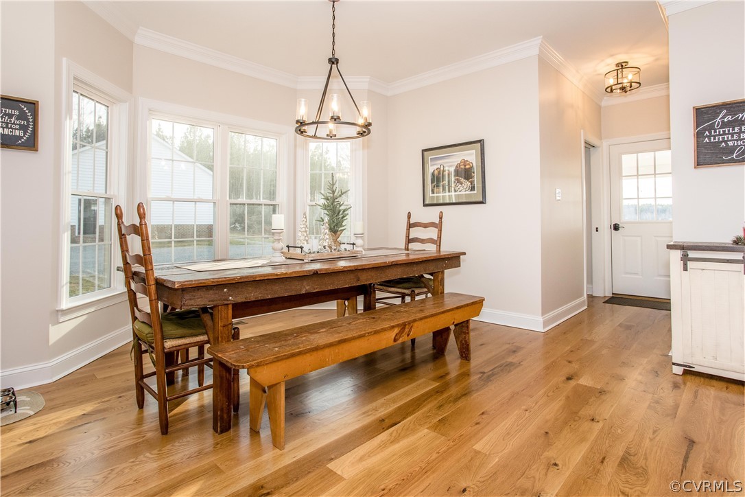 13790 Glebe Road Dewitt, VA 23840 - Photo 7 of 39 a dining room with wooden floor a chandelier a wooden table and chairs