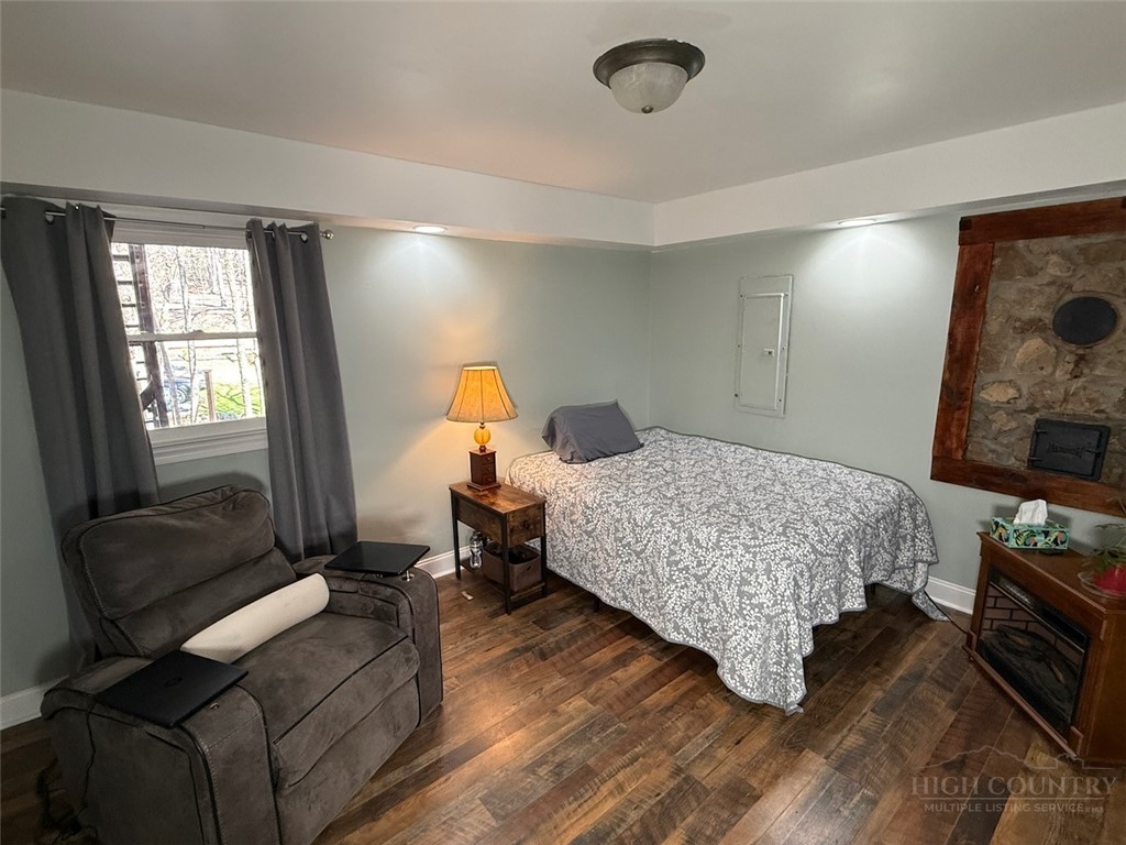 2291 Pine Swamp Road Fleetwood, NC 28626 - Photo 35 of 37 a bedroom with a bed and wooden floor