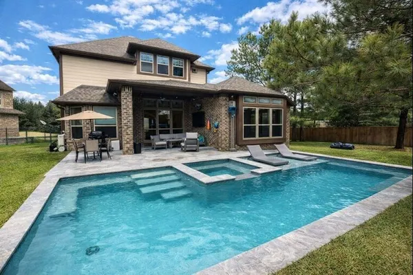 a view of a house with swimming pool and sitting area