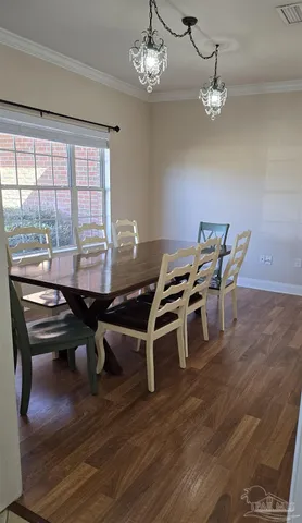 a dining room with furniture a chandelier and wooden floor
