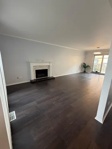 an empty room with wooden floor and fireplace