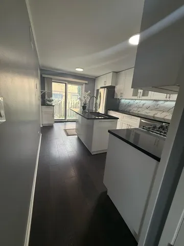 a kitchen with stainless steel appliances a sink stove and cabinets