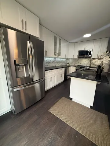 a kitchen with stainless steel appliances granite countertop a refrigerator a stove a sink dishwasher and a refrigerator