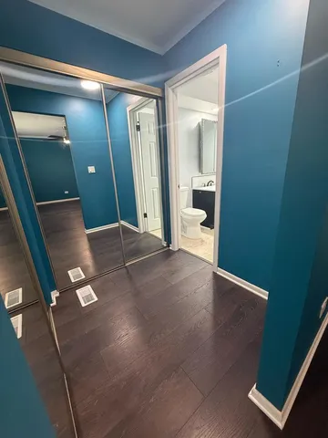 an empty room with wooden floor and bathroom