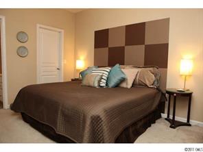 215 Dawn Mist Lane, Unit 215 Fort Mill, SC 29708 - Photo 10 of 16 a bedroom with a bed a mirror and lamp