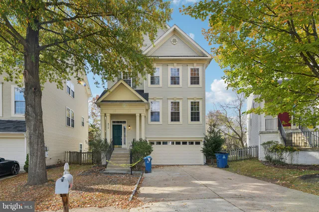 a front view of a house with a yard and potted plants