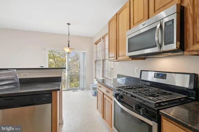 a kitchen with stainless steel appliances granite countertop a stove and a microwave