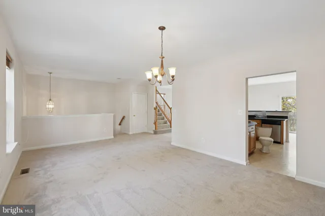 a view of a room with a hanging light and kitchen