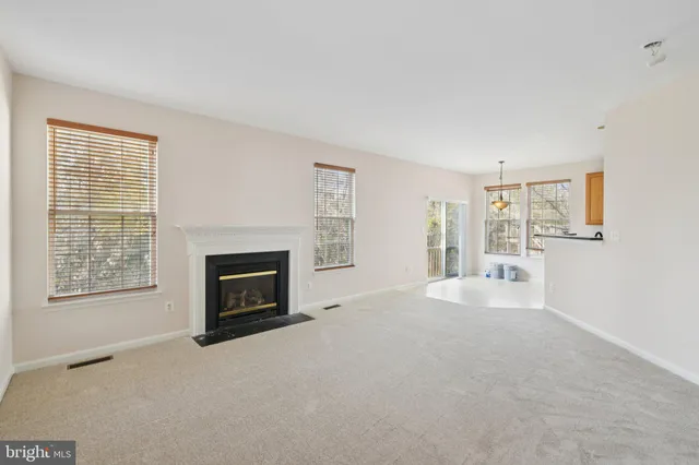 a view of an empty room with a fireplace and a window