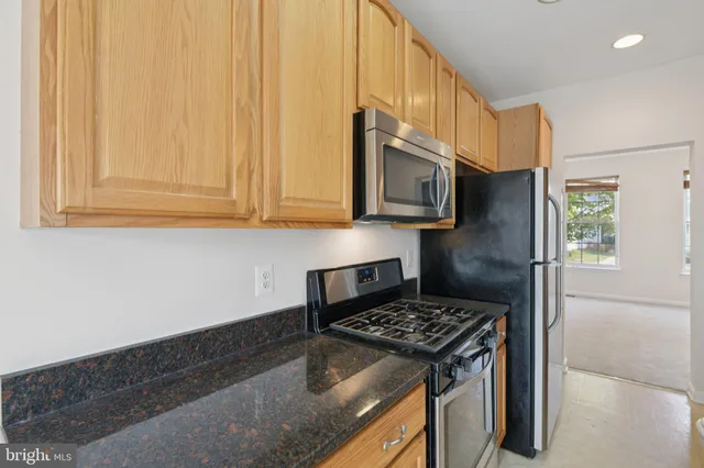 a kitchen with stainless steel appliances granite countertop a stove a refrigerator and a microwave