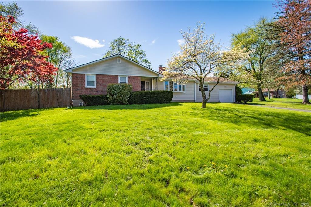 a front view of a house with yard and trees