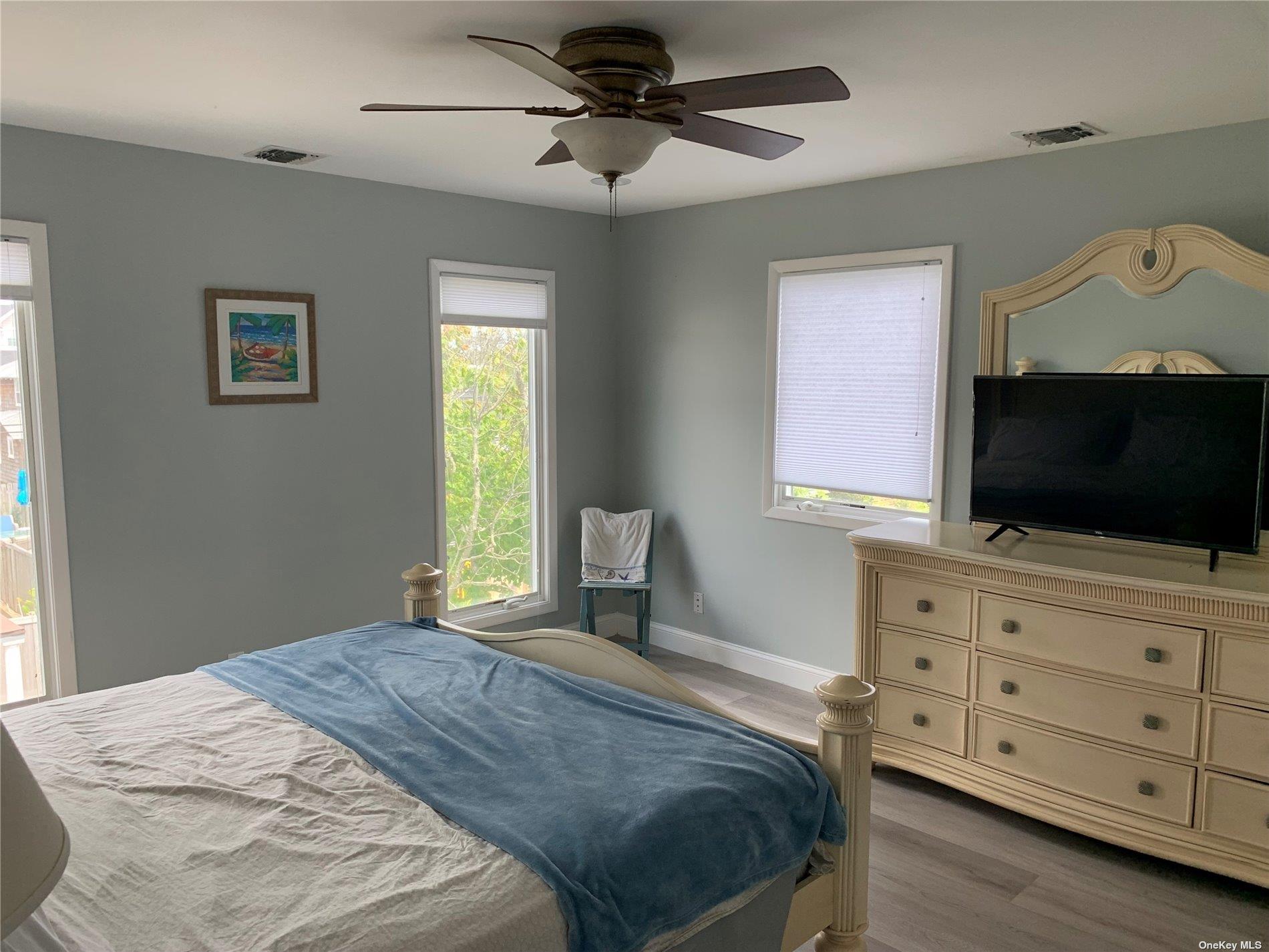 187 Cottage Walk Ocean Beach, NY 11770 - Photo 7 of 9 a bedroom with a bed and a flat screen tv