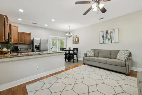 a living room with furniture and a dining table with kitchen view