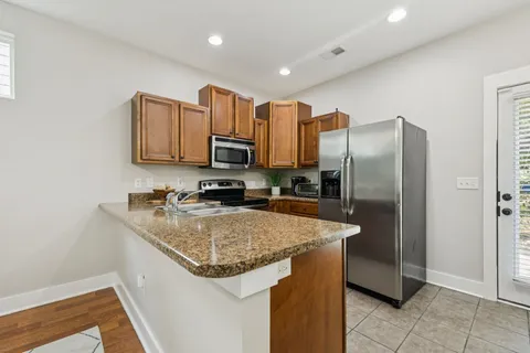 a kitchen with stainless steel appliances granite countertop a refrigerator a sink a stove a microwave and island