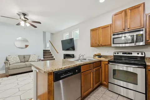 a kitchen with stainless steel appliances granite countertop a stove microwave and sink