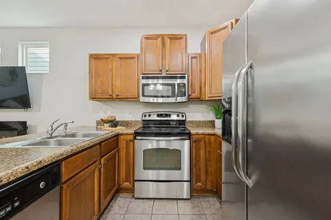a kitchen with stainless steel appliances granite countertop a stove a refrigerator and a sink