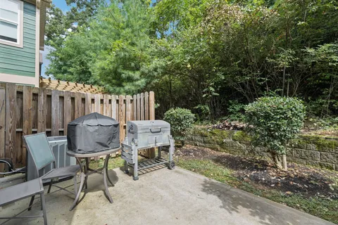 a view of a chair and table in backyard of the house
