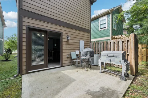 a view of a patio with a table and chairs and a barbeque