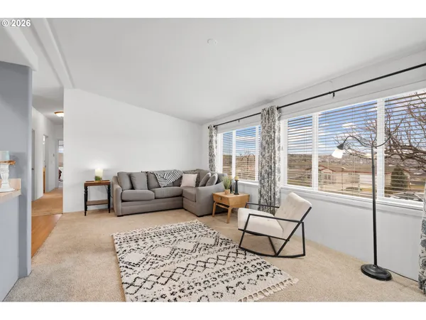a living room with furniture and a view of kitchen