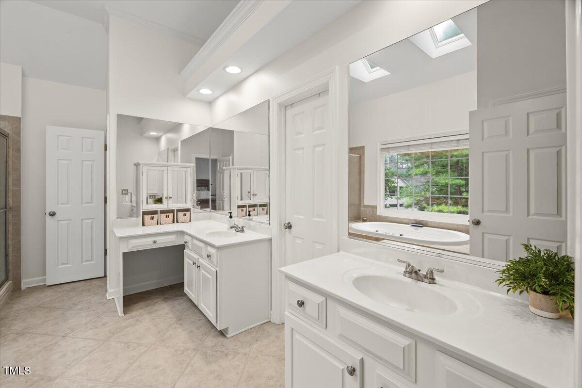 12204 Kaysmount Court Raleigh, NC 27614 - Photo 27 of 50 a bathroom with a sink large mirror and a bathtub