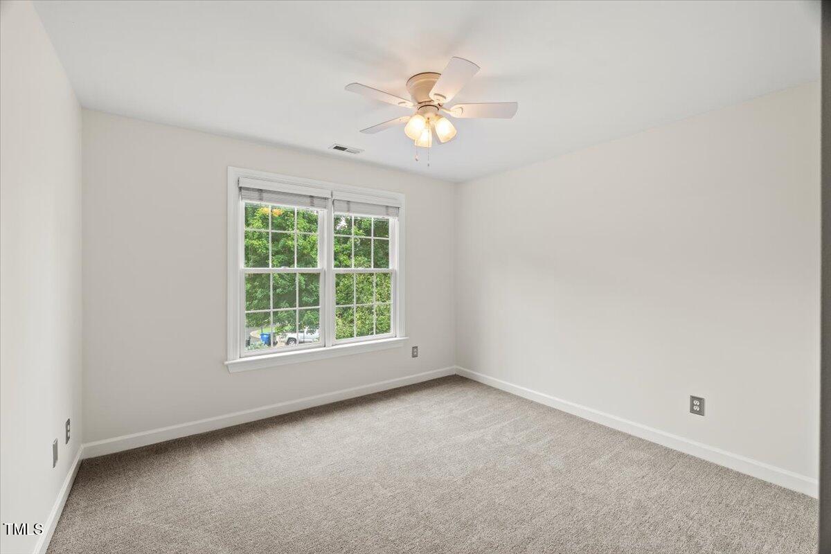 12204 Kaysmount Court Raleigh, NC 27614 - Photo 34 of 50 an empty room with a chandelier fan and windows