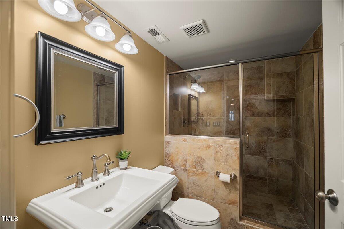 12204 Kaysmount Court Raleigh, NC 27614 - Photo 47 of 50 a bathroom with a toilet a sink and mirror