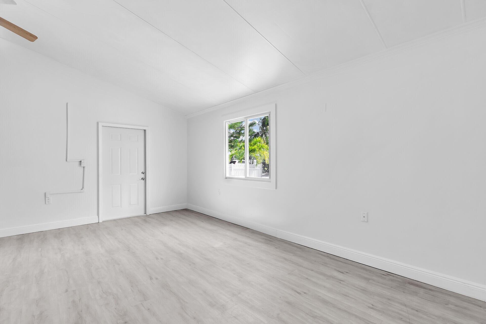 417 95th Street Marathon, FL 33050 - Photo 13 of 28 a view of an empty room with wooden floor and a window