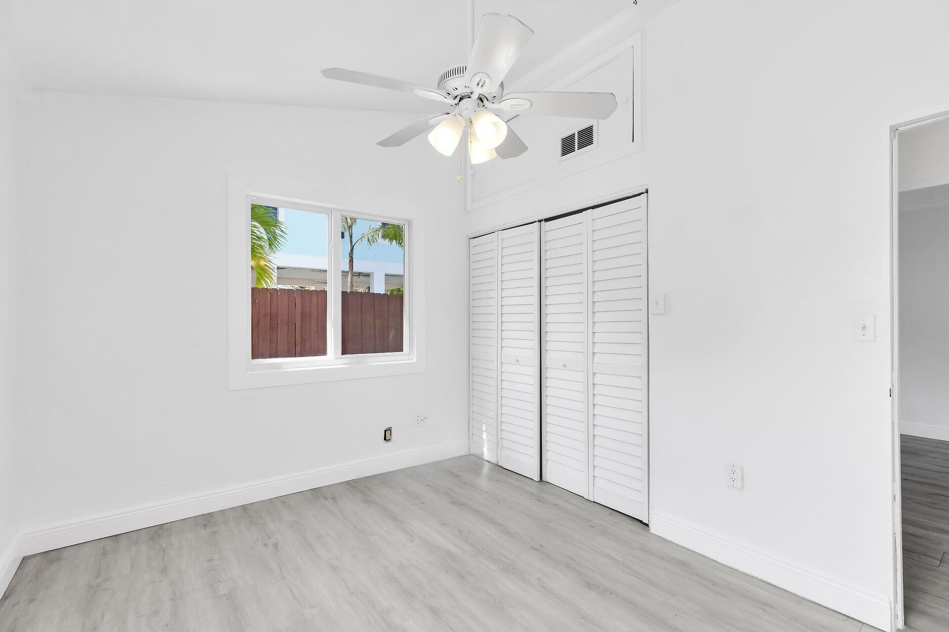 417 95th Street Marathon, FL 33050 - Photo 23 of 28 an empty room with wooden floor chandelier fan and windows