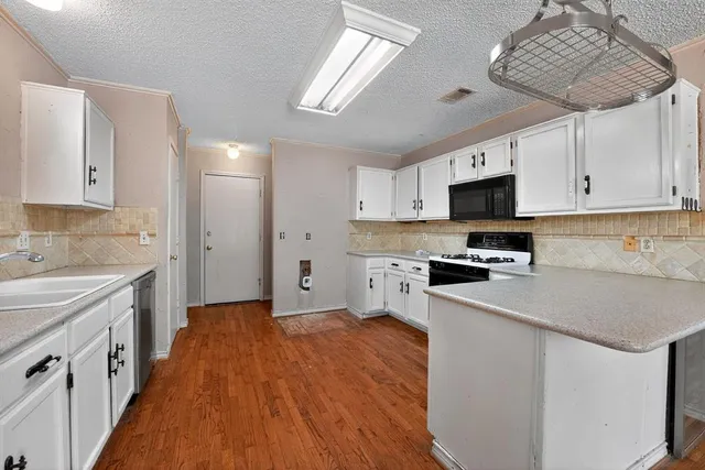 a kitchen with stainless steel appliances a stove sink microwave and cabinets