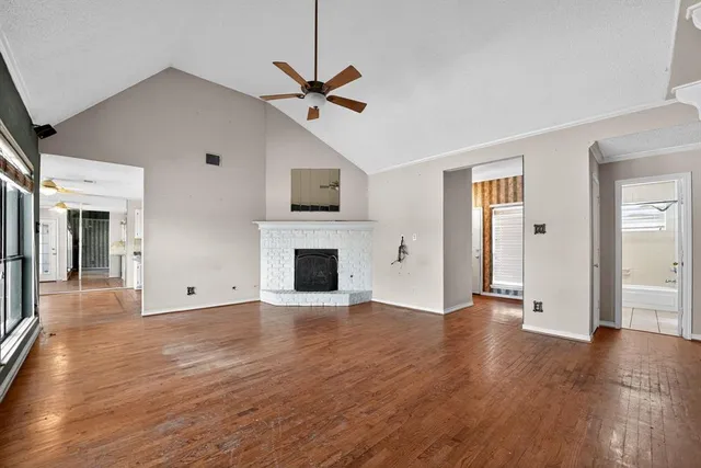 a view of a livingroom with wooden floor and a ceiling fan