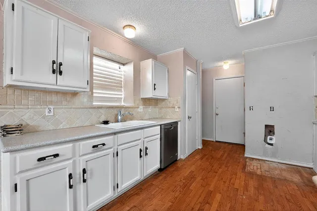 a kitchen with white cabinets and sink