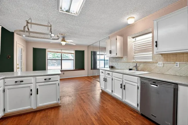 a large kitchen with cabinets wooden floor and stainless steel appliances