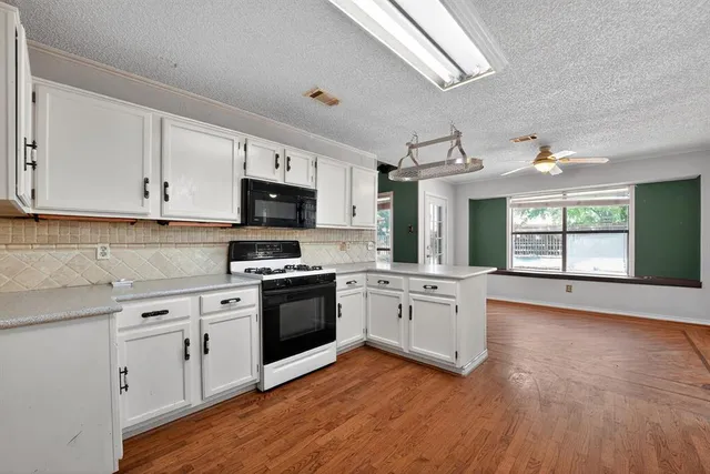 a kitchen with granite countertop white cabinets and stainless steel appliances