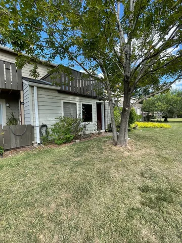 a view of a house with a yard and tree s