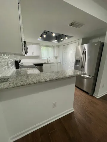 a view of a kitchen with a sink and refrigerator